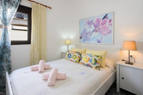 a bedroom with a white bed with pink towels on it at Caleta Blue House - MacaronesiaHomes in Caleta de Caballo