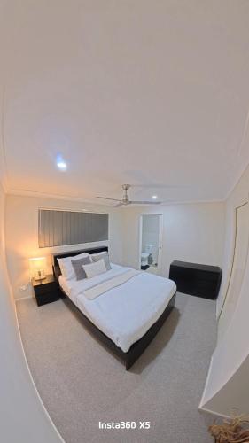 a bedroom with a large white bed in a room at Canaan Oasis in Pimpama