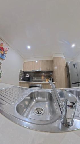 a kitchen with a stainless steel sink in a kitchen at Canaan Oasis in Pimpama