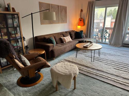 a living room with a couch and a table at Alpine Charm By Alyeska Sleeps 6 in Girdwood