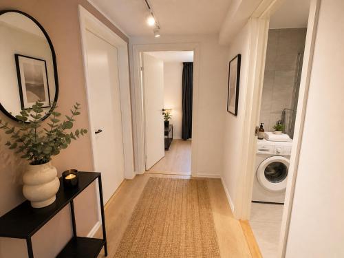 a hallway with a washing machine and a mirror at 70 Degrees North City Apartments in Tromsø