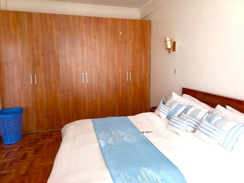 a bedroom with a large bed with blue and white pillows at Laneens Apartments in Eldoret