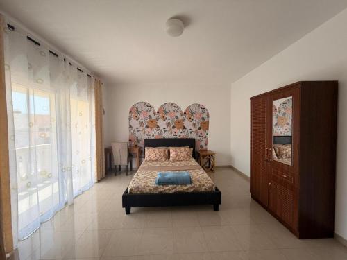 a bedroom with a bed and a large window at Anta's House Sipres - Chambre calme et confortable in Dakar