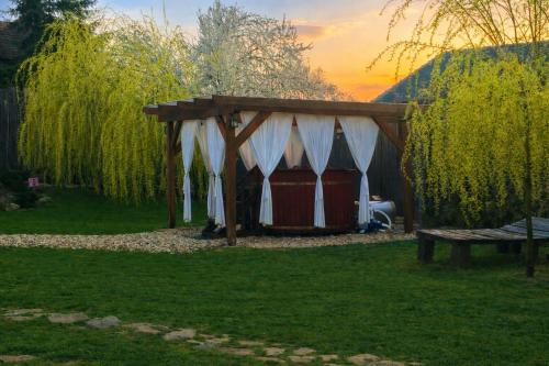 a tent with a table and a bench in a yard at Mátrai pincés udvar in Mátramindszent