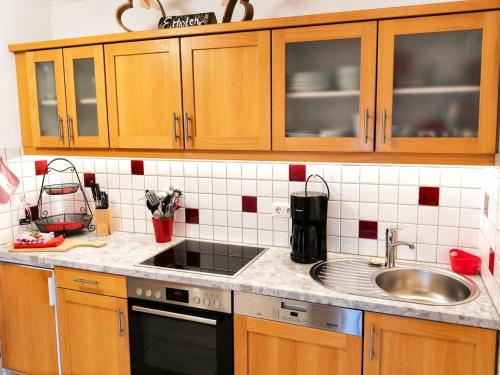 a kitchen with wooden cabinets and a sink at Gästehaus Schönfeld in Reit im Winkl