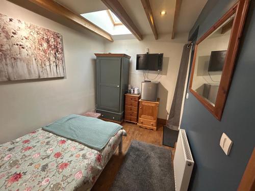 a small bedroom with a bed and a tv at Cobblers Lodge in Somersham