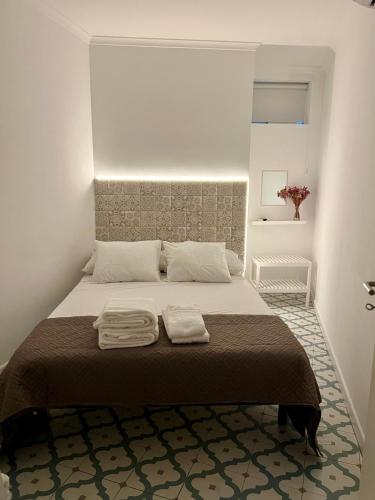 a bedroom with a bed with two towels on it at Elvas Centro Histórico Largo do Refúgio in Elvas