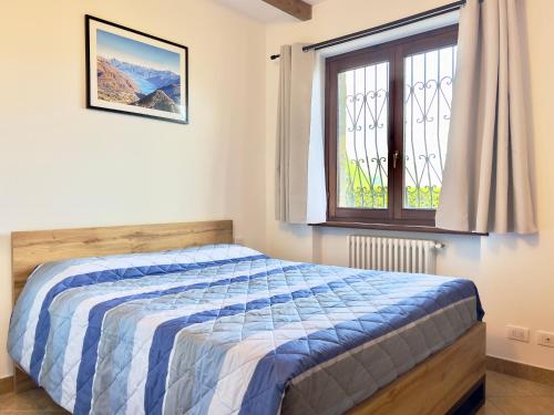 a bedroom with a bed and a window at Chalet San Primo in Castiglione dʼIntelvi