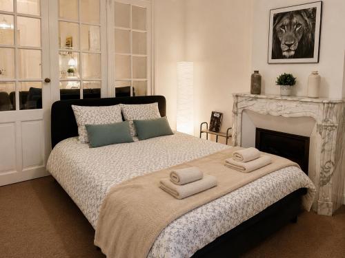 a bedroom with a bed with towels on it at Appartement calme et spacieux - Garage vélo in Saint-Quentin