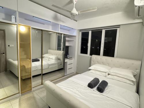 a bedroom with a large white bed with black shoes on it at Araam Retreat Deluxe in Male City