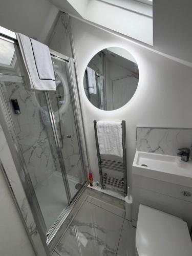 a bathroom with a shower and a sink and a mirror at The Lenton House in Nottingham