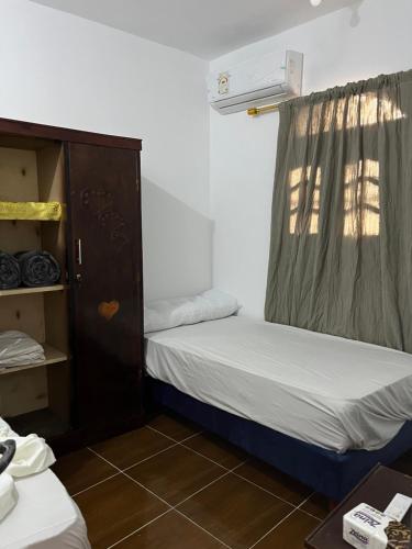 a small room with two beds and a closet at Farida Nile view in Luxor