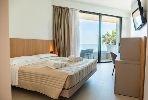 a hotel room with a bed with towels on it at Terradamare Suites in Monopoli