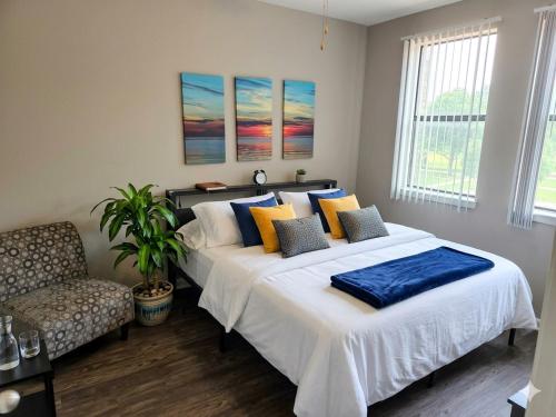 a bedroom with two beds and a chair and windows at King Aqua Suite Walkable Legacy West King Bed, Pool & Gym in Plano