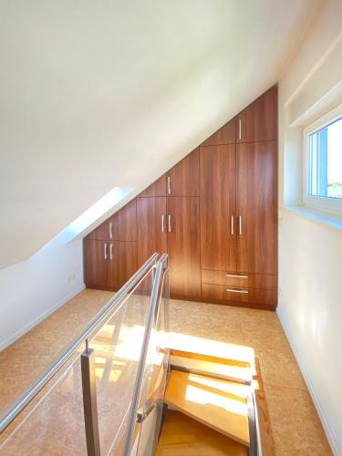 a staircase in a house with wooden cabinets at Midi-Maisonette mit kleiner Dachterrasse und Blick ins Grüne in Petersberg