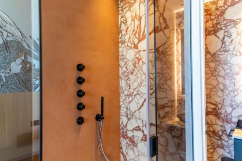 a shower with black knobs on a wall at Terradamare Suites in Monopoli