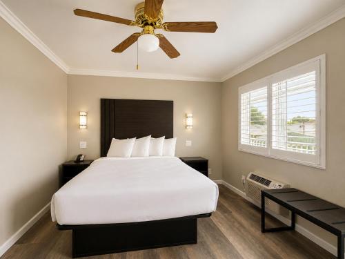 a bedroom with a bed and a ceiling fan at Rockview Inn and Suites - Morro Bay CA in Morro Bay