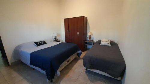 a bedroom with two beds and a wooden cabinet at Departamento Olivia in Ushuaia