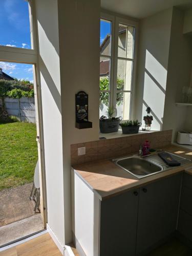 a kitchen with a sink and a window at L'Escapade Chablisienne in Chablis