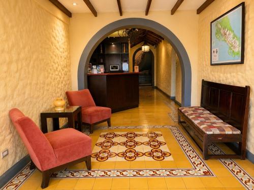a living room with two chairs and a couch at Hotel 1915 INN & SUITES in Alajuela