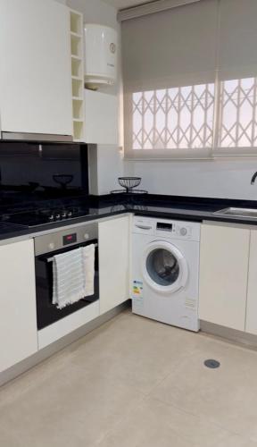a kitchen with a washing machine and a washer at 3 Ls APARTAMENTO in Luanda
