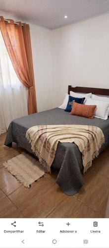 a bedroom with a bed with a blanket on it at Excelente casa com isolamento térmico, dois quarto in Itapoa