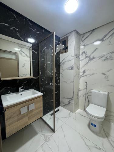 a bathroom with a toilet and a sink and a shower at Résidence Maryam in Nador