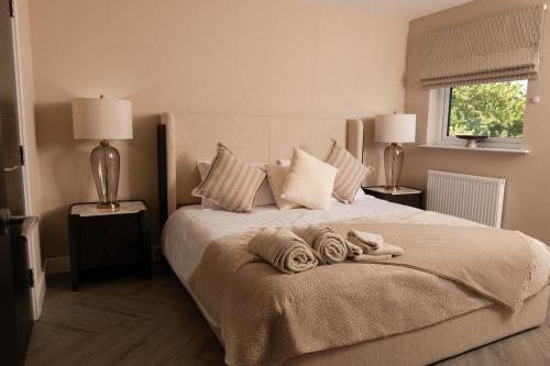 a bedroom with a large bed with towels on it at Castlecroft House with Hot Tub in Dungiven