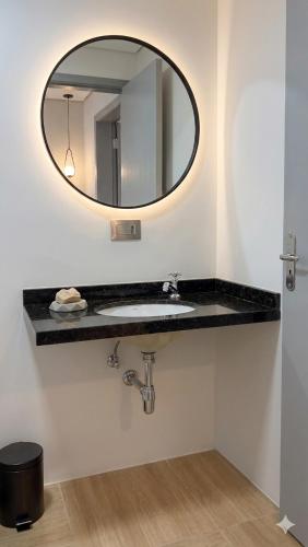 a bathroom with a sink and a mirror at Excelente casa com isolamento térmico, dois quarto in Itapoa