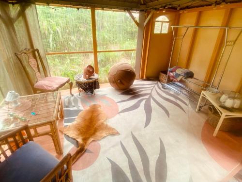 a living room with a large window and a table at Artsy Cabin on Organic Farm in Naalehu