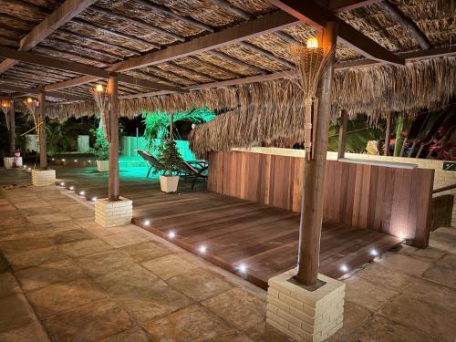 a pavilion with a table and chairs in a resort at Oasis Tropical in Paracuru