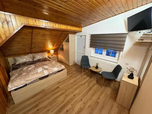 a bedroom with a large bed and a flat screen tv at Penzion Oáza Hřensko in Hřensko