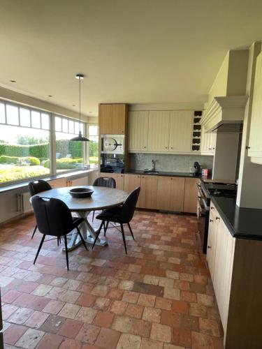 a kitchen with a table and chairs in a room at Vakantiehuis Vloethem in Zedelgem