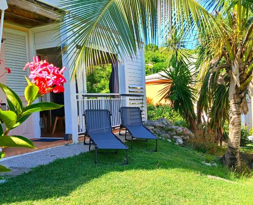 two blue chairs sitting on the grass in front of a house at Karpé diem in Saint-François