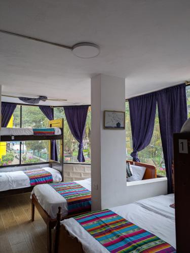 a bedroom with two beds and a window at Crater Eruption Backpacker Hostel in Baños