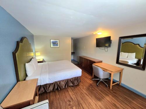 a hotel room with a bed and a desk and a mirror at Brentwood Inn Richmond South in Beulah Village