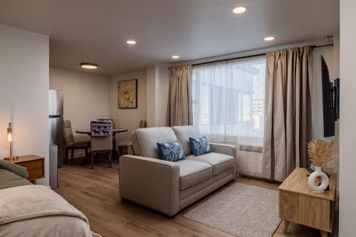 a bedroom with a couch and a chair in front of a window at Modern Downtown Studio - King Bed - Inlet Views in Anchorage