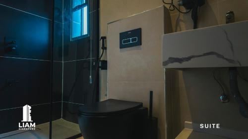 a bathroom with a black toilet and a shower at Studio Apartment -LIAM Signature Akowonjo Egbeda in Akinde