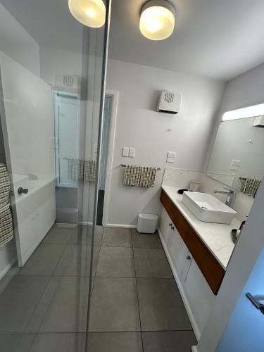 a bathroom with a sink and a shower and a mirror at Amberley Lodge in Amberley