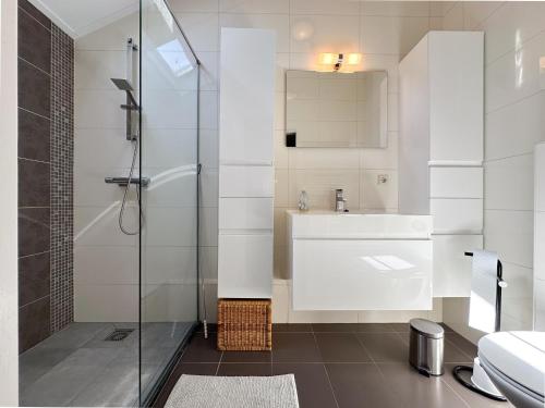 a bathroom with a shower and a sink and a toilet at Zout en Peper in Kattendijke