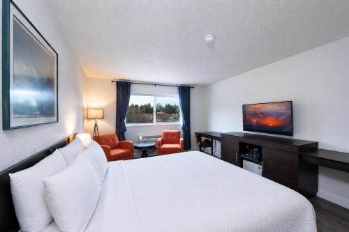 a hotel room with a bed and a desk at Hotel International in Lynnwood