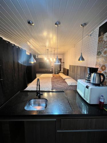 a kitchen counter with a sink and a microwave at Quarto Aconchegante N 3 in Rio Negro