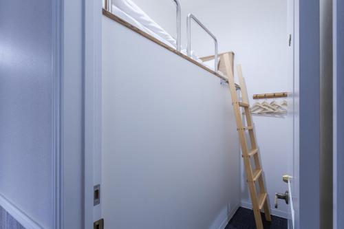 a room with a ladder next to a white wall at HOTEL THE CUBE Naha Kokusai Street in Naha