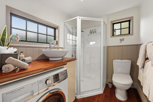a bathroom with a toilet sink and a shower at Private seaside couples hideaway in Kaka Point