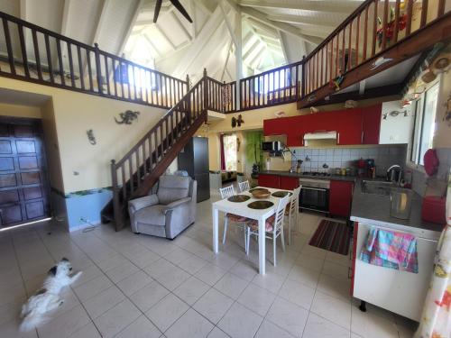 a kitchen with a table and a dog in a room at KAZ A CE TI MOUN LA, à Deshaies in Deshaies