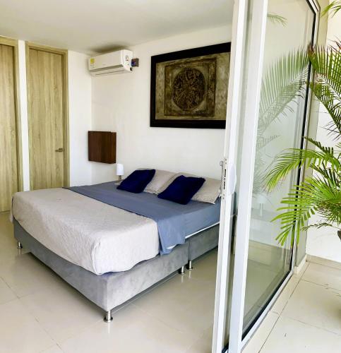 a bedroom with a bed with blue pillows at BlueMar Cartagena in Cartagena de Indias
