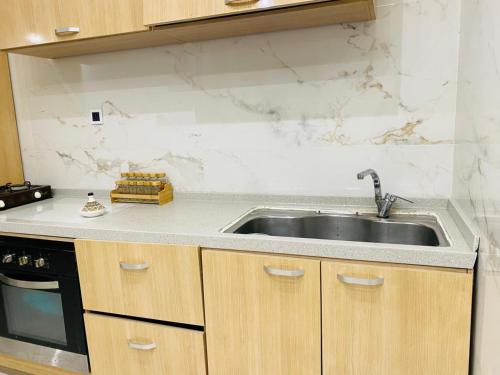 a kitchen with a sink and a stove at Appartement Kais in Laayoune