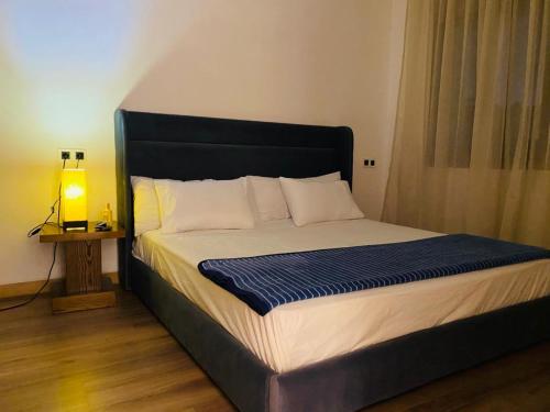 a bed with a black headboard in a room at Appartement Kais in Laayoune