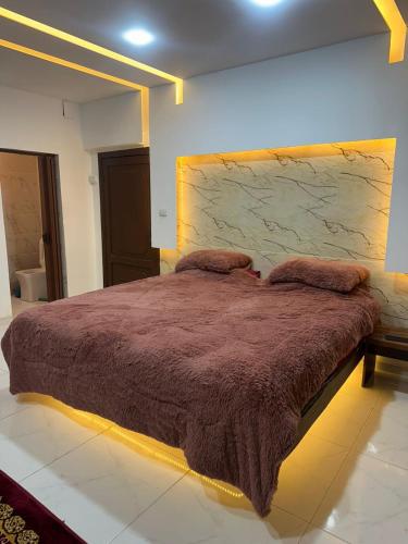 a bedroom with a large bed with a brown blanket at La mira chalet in Madaba