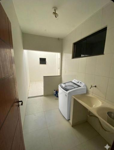 a small bathroom with a sink and a washing machine at 2 quartos com garagem coberta in Vitória da Conquista